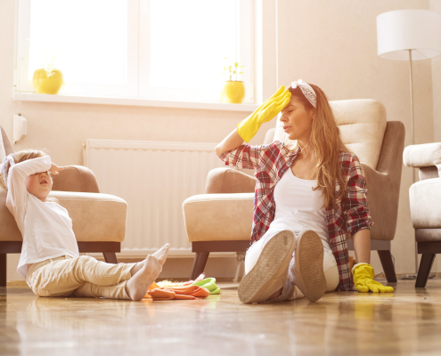 mother daughter feeling exhausted after cleaning home together