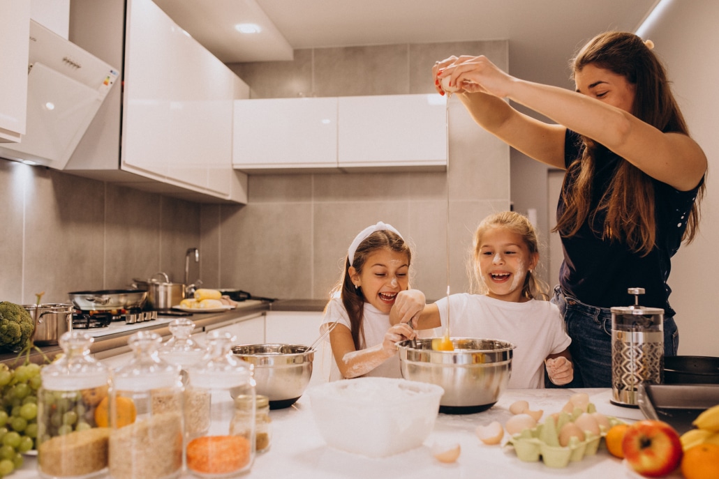 Mother with two daughters at kitchen baking